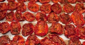 How To Make Sun Dried Tomatoes In The Oven – With Ease! Looking for a simple method using your oven to make sun dried tomatoes from the fresh tomatoes growing in your garden this summer? Harvesting fresh, ripe tomatoes from your garden and turning them into sun-dried tomatoes has a certain magical quality. Being able to concentrate and save the fresh taste of summer the whole year round really is special. The good news is that when it comes to preserving tomatoes – it honestly doesn’t get much easier than creating delicious sun dried tomatoes in your oven. And when dried, the super sweet flavor of the tomatoes rises to a whole new level. And can it ever add all kinds of amazing versatility to your meals, appetizers and more! Sun dried tomatoes in the oven Making sun dried tomatoes in the oven is a great way to make use of your ripe tomatoes. How To Make Sun Dried Tomatoes In The Oven Choosing the Best Tomatoes First, more than anything else, it’s important to pick the best of the best tomatoes before you start the dehydration process. Always be sure to select tomatoes that are firm, ripe, and meaty. Meaty tomatoes are not only thick and full of flavor, they also usually have far less seeds. San Marzano, Roma, Grape and cherry tomatoes are all great examples of tomato varieties that are perfect for making sun dried tomatoes. All are meaty and sweet – and all typically produce an abundance of tomatoes throughout the summer months. These features are essential for getting the best sun dried quality while in the oven. Because of their smaller size, the cherry and grape tomatoes have the added advantage of taking slightly less time in the oven. Preparing The Tomatoes – How to Make Sun Dried Tomatoes in the Oven Once you’ve chosen your preferred variety, it’s time to clean them. Gently rinse the tomatoes to eliminate any dirt and debris. With a fresh kitchen towel or paper towel, carefully pat them dry. Sun dried tomatoes Sun dried tomatoes are ready to be stored or used in a recipe fresh out of the oven. Subscribe to This Is My Garden! Get updates on the latest posts and more from This Is My Garden straight to your inbox. Your Email... SUBSCRIBE I consent to receiving emails and personalized ads. Next, cut the tomatoes in half. If they are small cherry or grape tomatoes, that is more than enough for drying in the oven. If using slightly larger varieties, cut into smaller but equal size pieces. Quartering or even cutting into eighths can usually produce the perfect size for dehydrating. Removing Excess Moisture and Seeds – How to Make Sun Dried Tomatoes in the Oven The next important step is to remove the seeds from the tomato slices before drying them. The watery membranes that surround the seed area holds a lot of moisture – and all of that excess water will greatly delay the oven’s drying effects. With a tiny spoon or by using your finger, carefully scoop out the seeds and remove the core. Be careful not to harm the flesh while doing this step. To pull out additional moisture, lightly sprinkle the tomatoes with salt. Give the salted slices roughly 30-40 minutes to sit. Blot them dry with a paper towel after they have rested. This technique will not only improve the flavor of your sun-dried tomatoes, it will also help the drying process to go smoother and faster. timg podcast banner 23 Preheating The Oven – How to Make Sun Dried Tomatoes in the Oven Now it’s time to heat up the oven! Preheat to 225°F (107°C) – this “low and slow” temperature is always best for making sun dried tomatoes in the oven. The low temperature and longer cooking time may take longer to dry them out – but it is exactly what gives your tomatoes great flavor! The tomatoes’ bright color and flavors are preserved by the low heat, which allows for a gradual drying process. Adding Additional Flavor As we know, the tomatoes themselves are already crammed with flavor. This can more than make them fantastic on their own. Because of this, when considering adding additional ingredients into the mix, it’s important to keep it simple. One option is olive oil. Once the tomatoes are cut side up on the parchment lined baking sheet, add a small drizzle of good quality olive oil. This small addition can add big flavor and can elevate the dish nicely. Another potential choice is adding Italian seasoning. The fragrant mixture of basil, thyme and oregano is very complimentary to traditional Italian flavors. Again, don’t overpower with too many additional ingredients. With the dynamic flavor of the tomato, simple is always best. Fresh and dry tomatoes Sun dried tomatoes pack in a lot of flavor and are full of vitamins, minerals and antioxidants. The Drying Process Now that your tomatoes are ready and your oven is preheated, it’s time to start drying. Begin by lining a rimmed baking sheet with parchment paper. Be sure none of your tomatoes overlap on the baking sheet. It’s very important to have one even layer. In addition, leaving a little room between each slice will ensure a nice, even drying of all of the tomatoes. On average, the tomatoes should dry in the oven for 3-4 hours. Depending on the temperature of your oven and the thickness of the tomato slices, the drying time may change. Because all of these factors vary, begin checking your tomatoes at the 2.5 hour mark. Continue to leave in the oven if you still see pockets of moisture and monitor frequently from outside the oven. Using the oven light helps to check when ready without letting the heat escape. When done, the tomatoes should look shriveled, leathery and dry. Oven dried with herbs Try adding herbs to your sun dried tomatoes for even more great flavor. Cool and Store – How to Make Sun Dried Tomatoes in the Oven When the drying process is complete, carefully remove and allow the tomatoes to finish cooling on the baking sheet. Once the tomatoes are at room temperature, transfer them to an airtight container or a glass jar. The tomatoes themselves can be kept in the refrigerator for up to 1-2 weeks. Adding a nice olive oil into the container before storing can make them last for an additional couple of weeks when refrigerated. For longer lasting sun-dried tomatoes, freezing is the way to go. You can freeze them in a resealable bag or freezer container. When kept in a sealed container, frozen sun dried tomatoes can last for more than a year. Enjoy the Flavor! One thing is for sure, making sun-dried tomatoes in the oven really is a simple process. And while the ingredients are simple as well, the flavor is pretty extraordinary! The tastes and textures will certainly up the level of your dishes and add a nice touch of summer no matter the time of year. Jarred cherry tom. in olive oil After drying your tomatoes, try storing in an airtight container. These also make great gifts for family, friends and guests alike. So, if you happen to have extra tomatoes from your harvest this year – be sure to not let any go to waste. Indulge in the satisfaction of sun-drying your tomatoes in your oven, and enjoy a bite of summer every time you open them up. They even make great presents too!