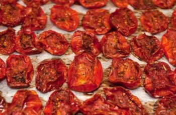 How To Make Sun Dried Tomatoes In The Oven – With Ease! Looking for a simple method using your oven to make sun dried tomatoes from the fresh tomatoes growing in your garden this summer? Harvesting fresh, ripe tomatoes from your garden and turning them into sun-dried tomatoes has a certain magical quality. Being able to concentrate and save the fresh taste of summer the whole year round really is special. The good news is that when it comes to preserving tomatoes – it honestly doesn’t get much easier than creating delicious sun dried tomatoes in your oven. And when dried, the super sweet flavor of the tomatoes rises to a whole new level. And can it ever add all kinds of amazing versatility to your meals, appetizers and more! Sun dried tomatoes in the oven Making sun dried tomatoes in the oven is a great way to make use of your ripe tomatoes. How To Make Sun Dried Tomatoes In The Oven Choosing the Best Tomatoes First, more than anything else, it’s important to pick the best of the best tomatoes before you start the dehydration process. Always be sure to select tomatoes that are firm, ripe, and meaty. Meaty tomatoes are not only thick and full of flavor, they also usually have far less seeds. San Marzano, Roma, Grape and cherry tomatoes are all great examples of tomato varieties that are perfect for making sun dried tomatoes. All are meaty and sweet – and all typically produce an abundance of tomatoes throughout the summer months. These features are essential for getting the best sun dried quality while in the oven. Because of their smaller size, the cherry and grape tomatoes have the added advantage of taking slightly less time in the oven. Preparing The Tomatoes – How to Make Sun Dried Tomatoes in the Oven Once you’ve chosen your preferred variety, it’s time to clean them. Gently rinse the tomatoes to eliminate any dirt and debris. With a fresh kitchen towel or paper towel, carefully pat them dry. Sun dried tomatoes Sun dried tomatoes are ready to be stored or used in a recipe fresh out of the oven. Subscribe to This Is My Garden! Get updates on the latest posts and more from This Is My Garden straight to your inbox. Your Email... SUBSCRIBE I consent to receiving emails and personalized ads. Next, cut the tomatoes in half. If they are small cherry or grape tomatoes, that is more than enough for drying in the oven. If using slightly larger varieties, cut into smaller but equal size pieces. Quartering or even cutting into eighths can usually produce the perfect size for dehydrating. Removing Excess Moisture and Seeds – How to Make Sun Dried Tomatoes in the Oven The next important step is to remove the seeds from the tomato slices before drying them. The watery membranes that surround the seed area holds a lot of moisture – and all of that excess water will greatly delay the oven’s drying effects. With a tiny spoon or by using your finger, carefully scoop out the seeds and remove the core. Be careful not to harm the flesh while doing this step. To pull out additional moisture, lightly sprinkle the tomatoes with salt. Give the salted slices roughly 30-40 minutes to sit. Blot them dry with a paper towel after they have rested. This technique will not only improve the flavor of your sun-dried tomatoes, it will also help the drying process to go smoother and faster. timg podcast banner 23 Preheating The Oven – How to Make Sun Dried Tomatoes in the Oven Now it’s time to heat up the oven! Preheat to 225°F (107°C) – this “low and slow” temperature is always best for making sun dried tomatoes in the oven. The low temperature and longer cooking time may take longer to dry them out – but it is exactly what gives your tomatoes great flavor! The tomatoes’ bright color and flavors are preserved by the low heat, which allows for a gradual drying process. Adding Additional Flavor As we know, the tomatoes themselves are already crammed with flavor. This can more than make them fantastic on their own. Because of this, when considering adding additional ingredients into the mix, it’s important to keep it simple. One option is olive oil. Once the tomatoes are cut side up on the parchment lined baking sheet, add a small drizzle of good quality olive oil. This small addition can add big flavor and can elevate the dish nicely. Another potential choice is adding Italian seasoning. The fragrant mixture of basil, thyme and oregano is very complimentary to traditional Italian flavors. Again, don’t overpower with too many additional ingredients. With the dynamic flavor of the tomato, simple is always best. Fresh and dry tomatoes Sun dried tomatoes pack in a lot of flavor and are full of vitamins, minerals and antioxidants. The Drying Process Now that your tomatoes are ready and your oven is preheated, it’s time to start drying. Begin by lining a rimmed baking sheet with parchment paper. Be sure none of your tomatoes overlap on the baking sheet. It’s very important to have one even layer. In addition, leaving a little room between each slice will ensure a nice, even drying of all of the tomatoes. On average, the tomatoes should dry in the oven for 3-4 hours. Depending on the temperature of your oven and the thickness of the tomato slices, the drying time may change. Because all of these factors vary, begin checking your tomatoes at the 2.5 hour mark. Continue to leave in the oven if you still see pockets of moisture and monitor frequently from outside the oven. Using the oven light helps to check when ready without letting the heat escape. When done, the tomatoes should look shriveled, leathery and dry. Oven dried with herbs Try adding herbs to your sun dried tomatoes for even more great flavor. Cool and Store – How to Make Sun Dried Tomatoes in the Oven When the drying process is complete, carefully remove and allow the tomatoes to finish cooling on the baking sheet. Once the tomatoes are at room temperature, transfer them to an airtight container or a glass jar. The tomatoes themselves can be kept in the refrigerator for up to 1-2 weeks. Adding a nice olive oil into the container before storing can make them last for an additional couple of weeks when refrigerated. For longer lasting sun-dried tomatoes, freezing is the way to go. You can freeze them in a resealable bag or freezer container. When kept in a sealed container, frozen sun dried tomatoes can last for more than a year. Enjoy the Flavor! One thing is for sure, making sun-dried tomatoes in the oven really is a simple process. And while the ingredients are simple as well, the flavor is pretty extraordinary! The tastes and textures will certainly up the level of your dishes and add a nice touch of summer no matter the time of year. Jarred cherry tom. in olive oil After drying your tomatoes, try storing in an airtight container. These also make great gifts for family, friends and guests alike. So, if you happen to have extra tomatoes from your harvest this year – be sure to not let any go to waste. Indulge in the satisfaction of sun-drying your tomatoes in your oven, and enjoy a bite of summer every time you open them up. They even make great presents too!